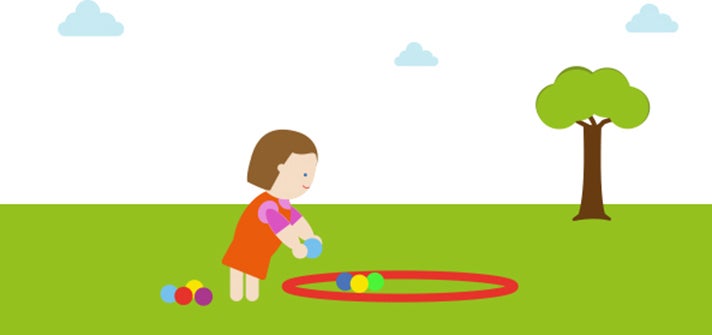 Toddler putting multicoloured balls inside a red hoop