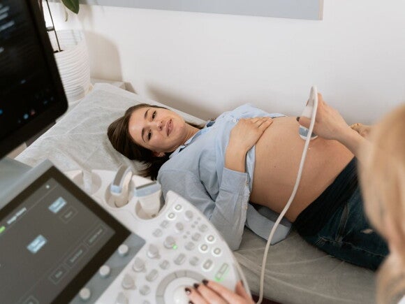Pregnant woman receiving an ultrasound by a technician