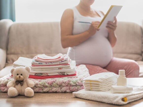 Pregnant woman packing with a list 