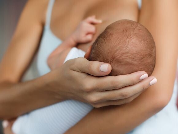 Woman holding small baby whilst breastfeeding