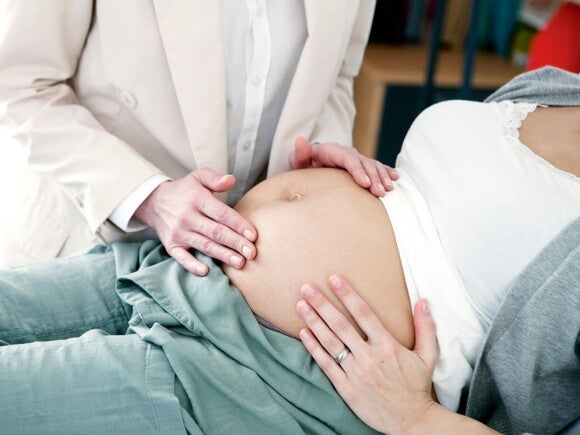 Pregnant woman at an appointment with belly being checked