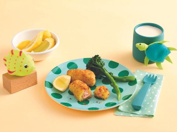 Cripsy salmon nuggets on a green spotted plate with yellow background