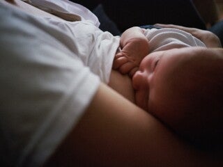 Mother breastfeeding baby in dark