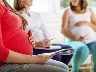 Pregnant woman in red shirt in a pre-natal class