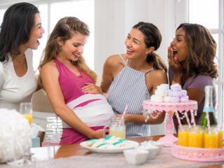  four woman playing a baby shower game