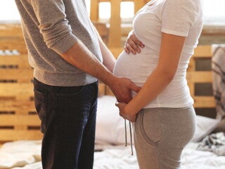 Pregnant woman and her partner holding her belly