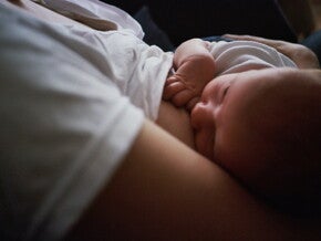 Mother breastfeeding baby in dark