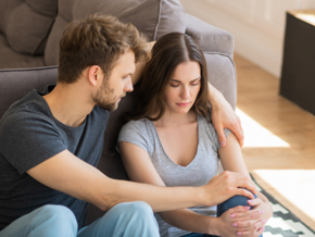 Male hugging female while sitting on the floor