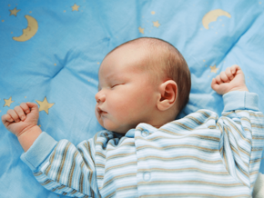 Young baby sleeping on a blanket with moon and stars