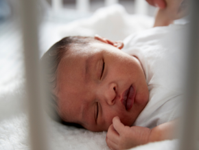newborn baby asleep in cot