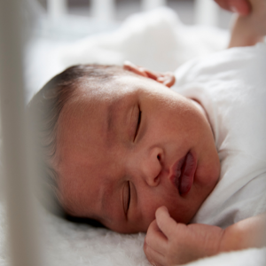 newborn baby asleep in cot