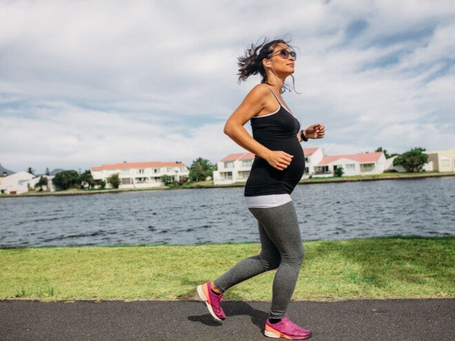 Pregnant woman exercising next to a river 