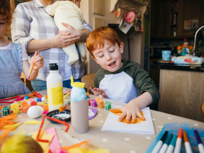 Toddler boy painting with his hands