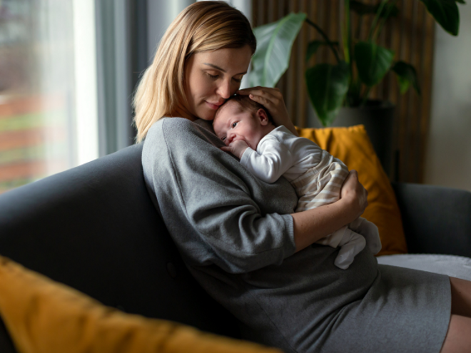 Mother holding her baby on the lounge cuddling