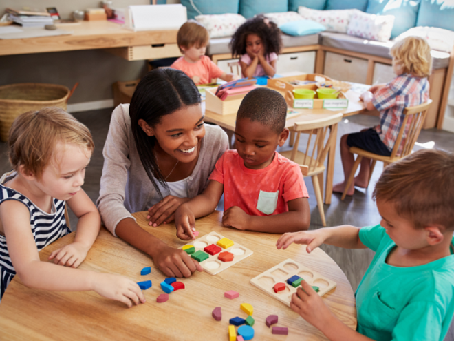 Teacher and children sitting around a table