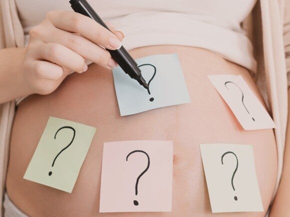 pregnant woman's belly with question marks