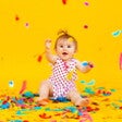 toddler sitting with confetti around